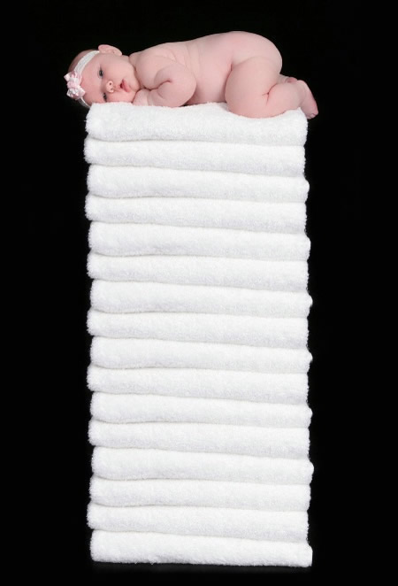 Una bimba che dorme su una pila di asciugamani